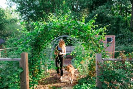 Sarah Jackson and her dog, Lucy walk through their garden 